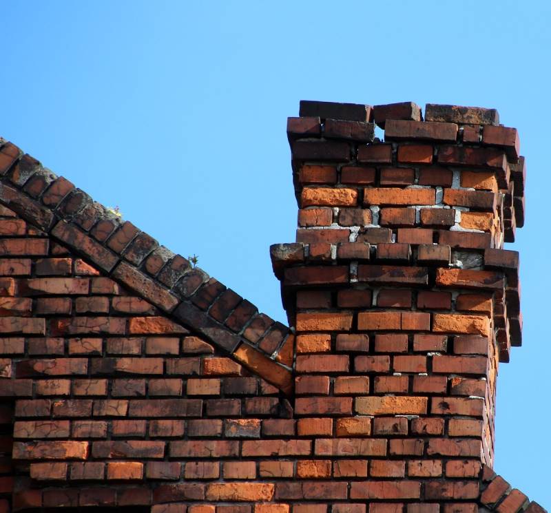Damaged chimney on an Rochester Hills home showing cracks and missing mortar